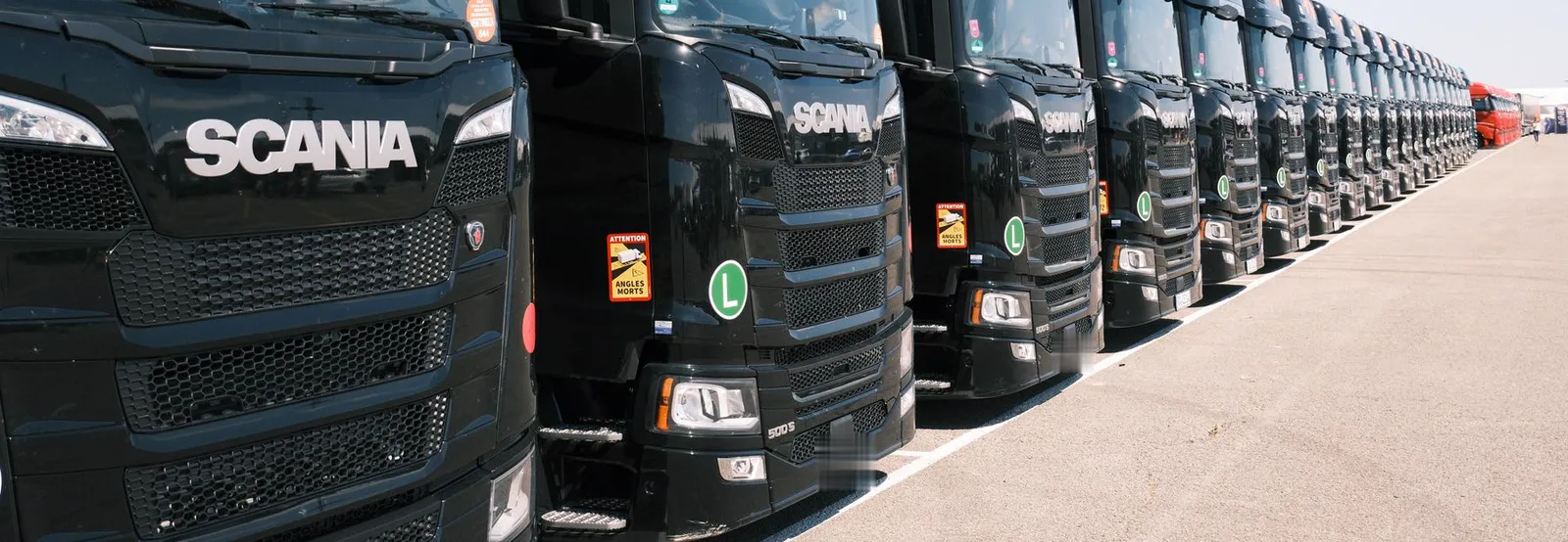 Frota de cavalos mecânicos Scania pretos enfileirados em um pátio